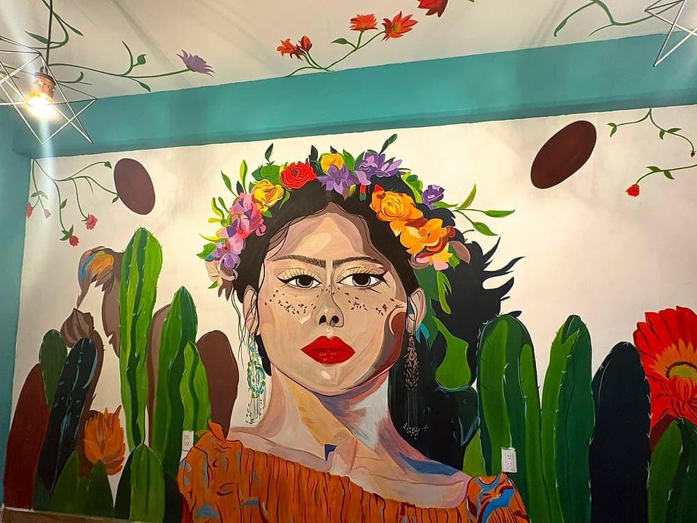 Rincón del local con el mural y la iluminación cálida