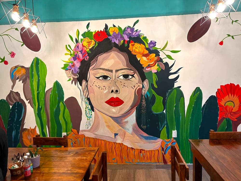 Mural de Frida Kahlo y cactus en el interior de Emilia Bonita